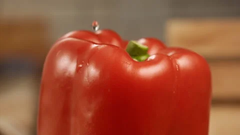 Close up shot of a drop of water falling on red bell pepper in slow motion Stock Footage 152902623