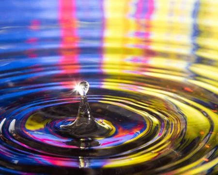 Close-up shot of drop of water falling into liquid with spiral waves reflecting Illustrazione stock