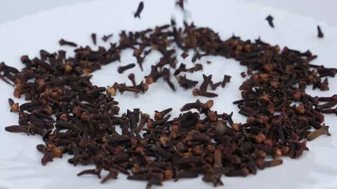 Close shot of dropping cloves over a white background Vídeo Stock 147691638
