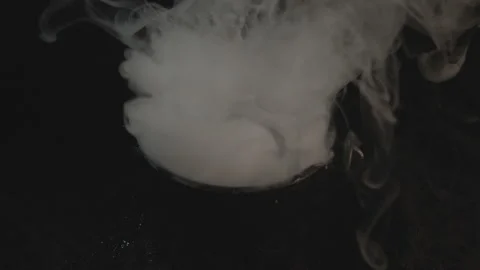 Close Up Shot of Dropping Dry Ice in Boiling Cauldron then Starts Smoking Stock Footage 139162715