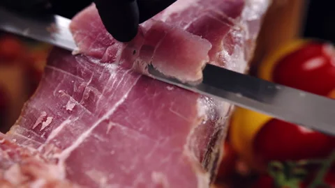 Close-up shot of dry-cured prosciutto slicing with sharp knife, red thin Stock-Footage 303144716