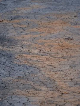 Close-up shot of an earthen ground composed of small grey rocks and muddy soil Foto stock