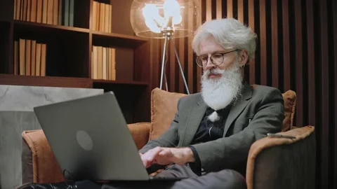Close-up shot of elderly businessman work at the laptop sitting in modern place Vídeo Stock 166968210