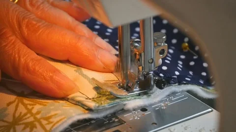 Close up shot of elderly female hands using sewing machine to stitch a bag Stock Footage 77172050