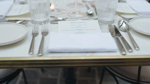 Close-up shot of an elegant table setting with cutlery, crystal glasses, folded Stockbeeldmateriaal 333675526
