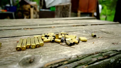 Close up shot of empty bullet shells laying on old wooded table Stock Footage 311485047