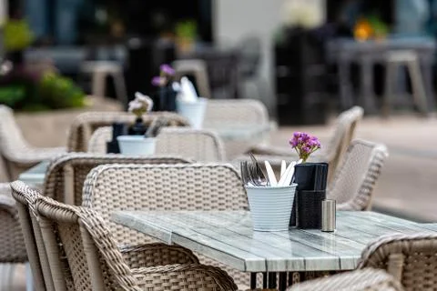 Close up shot of empty cafeteria or restaurant tables with chairs on street Stock Photos