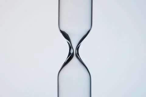 Close-up shot of empty glasware in shape of hourglass on grey 스톡 사진