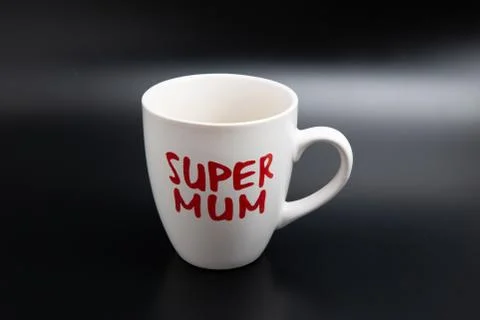 A close up shot of an empty white super mom coffee mug isolated on black  Stock Photos