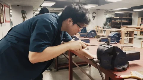 Close up shot of an Engineering Student hand file a piece of metal Video stock 102570297
