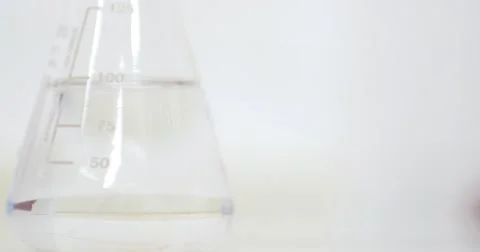 Close up shot of an Erlenmeyer flask and a person checking the water hardness Stock Footage 50928086