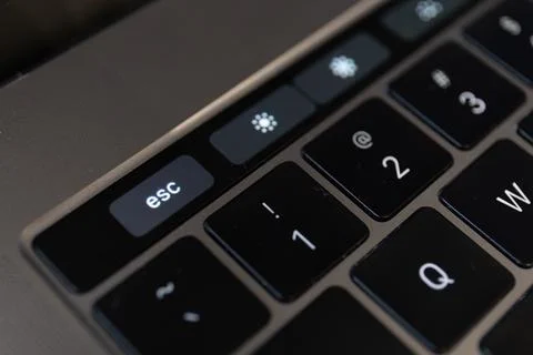 Close-up shot of the Escape key on touch bar of MacBook Pro laptop Stock Photos