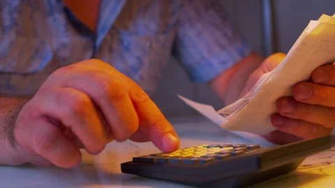 Close-up shot of evaluating personal finances under a lamp light Stock Footage 336982042