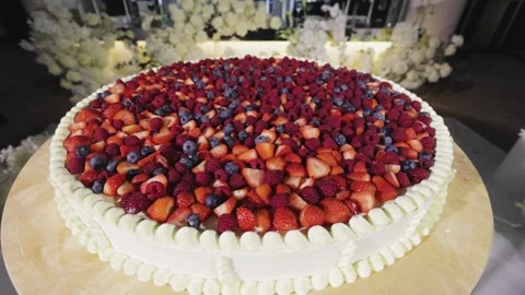 A close-up shot of an exquisite wedding cake adorned with an abundance of fresh Stock Footage 291346062