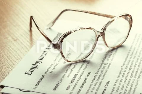 Close up shot of Eyeglasses on contract document papers business concept Stock Photos