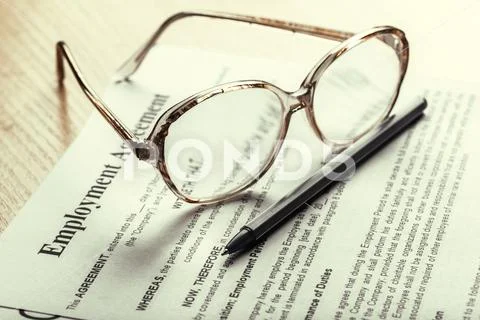 Close up shot of Eyeglasses on contract document papers business concept Stock Photos