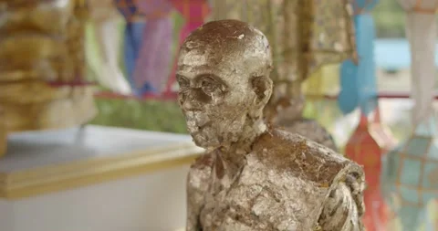 Close-up shot of the face of the Buddha emblazoned with gold leaf. Stock Footage 223382491