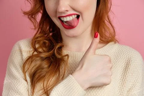 Close shot of the face of a red-haired girl with red manicure and lipstick Stock Photos