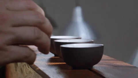 Close up shot of faceless people taking teacups from wooden desk indoors  Stock Footage 116627986