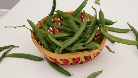Close shot of falling green beans over craft bowl Stock Footage 159638025