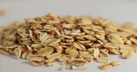 Close-up shot of falling rolled oats on a white background spinning on a table Stock Footage 152762633
