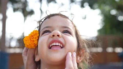 Close-up shot of an father hands gently placing a vibrant orange marigold f.. Video stock 320346632