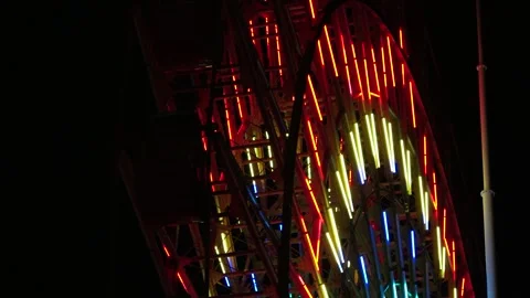 Close up shot of ferris wheel at night. Colorful led neon light decoration. Видео 279364386