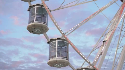 Close up shot of Ferris wheel spinning against colorful sunset sky Stock Footage 179990084