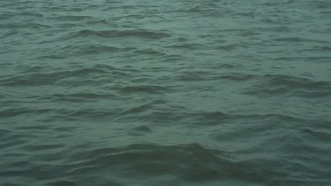 A close shot filling the frame with dark ocean waves moving rhythmically under Stock Footage 344485563