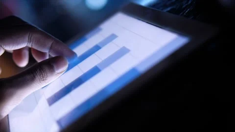 Close up shot of finger pointing at bar charts on digital tablet screen dur.. 스톡 동영상 333031146