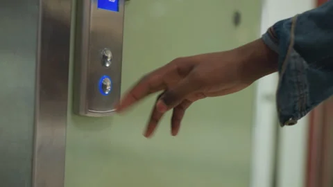 Close-up shot of finger pressing elevator button with illuminated blue arrow Stock Footage 316649505