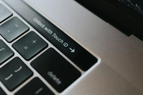 Close-up shot of a fingerprint sensor on touch bar of MacBook Pro with sign Stock Photos