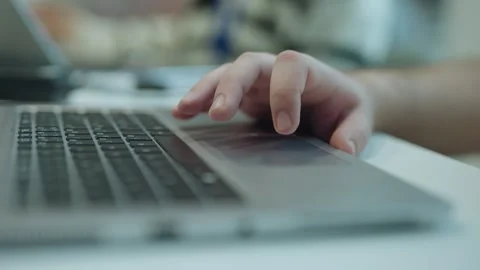 Close-up shot of fingers using a laptop trackpad during computer work at a desk Stock Footage 334024182
