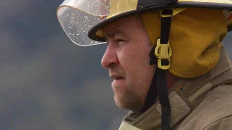 Close-up shot of a fireman as he surveys the scene and whistles Stock Footage 59515646