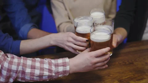 A close-up shot of five friends clinking their beer glasses together in Stock Footage 286821971