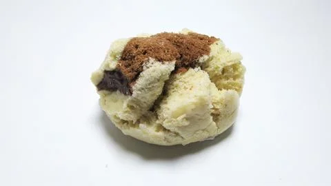 A close-up shot of a fluffy, light-colored pastry with a dark brown topping. Stock Photos