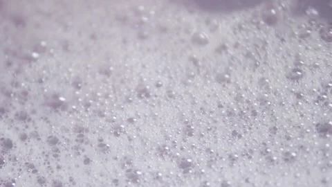 Close up shot of foam and soapy bubbles on a moving water surface, self care Stock Footage 307592041