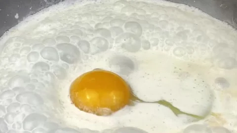 Close up shot of a fresh egg cracking and frying in a pan for breakfast cooking Stock Footage 324943419