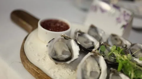 Close-up Shot of Fresh Oysters Served on Ice with Garnish and Sauce Stock Footage 340550085