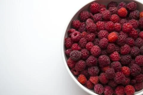 A close-up shot of a fresh raspberry in a white cup - perfect for a culinary Stock Photos