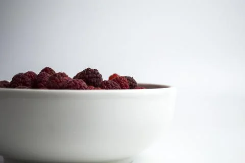 A close-up shot of a fresh raspberry in a white cup - perfect for a culinary Stock Photos