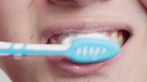 Close up shot of front teeth, lips jaw of a white man brushing with Stock Footage 261821928