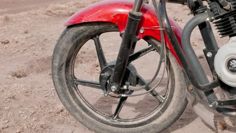 Close up shot of the front wheel of a bajaj motorcycle imported to africa, Vídeo Stock 223122582