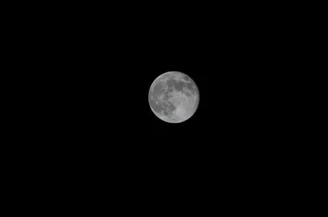 A close-up shot of the full moon captured through a telephoto lens, reveali.. Foto stock