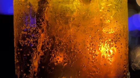 Close-up shot of a glass with a refreshing cold drink with pieces of ice and Video stock 137004439