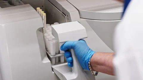 A close shot of a gloved hand putting a tray with test tubes in an automated lab Stock Footage 233128485