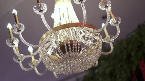 Close-up shot of a gorgeous, high-end crystal chandelier suspended from ceiling Video stock 299785186