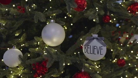 Close up shot of a green Christmas tree with white lights and red and white Stock Footage 324497358