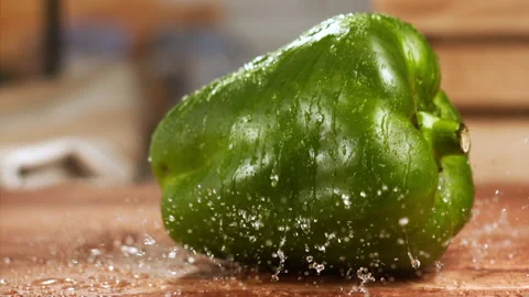 Close up shot of green pepper falling on a table in slow motion Stock Footage 152905292