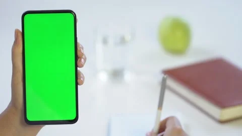Close-up shot of green screen template smartphone in female hands at home offise Stock Footage 141895869